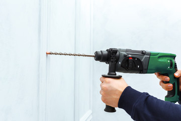 Use hammer drill to drill the wall