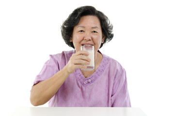 Wall Mural - Senior adult woman drinking soy milk