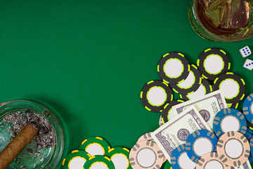 gambling, fortune and entertainment concept - close up of casino chips, whisky glass, playing cards and cigar on green table surface