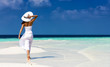 Attraktive Frau in weißem Kleid läuft auf einer Sandbank in den Tropen
