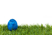 Blue Easter Egg On Green Grass On White Isolated Background