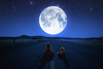 the girl with a teddy bear look at the moon.