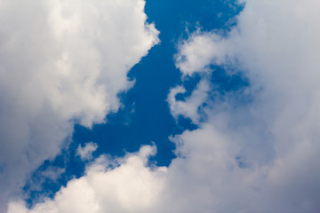 sun with sunbeams in a beautiful cloudy sky. blue sky is covered by white clouds