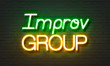 Improv group neon sign on brick wall background.
