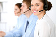 © rogerphoto - Call center operators. Focus at brunette business woman in headset