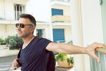 Male outdoor street portrait. Mid adult man walking at summer city Saint Jean de Luz streets, France.