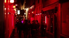 Groups Of Men Stroll Streets Of Red Light District At Night In Amsterdam