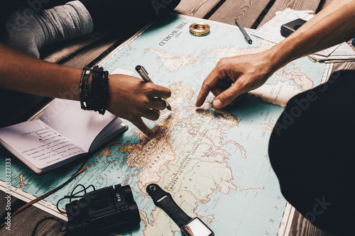 Fotomural Couple planning vacation using the world map.