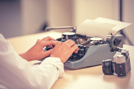 Journalist typing on retro machine, closeup