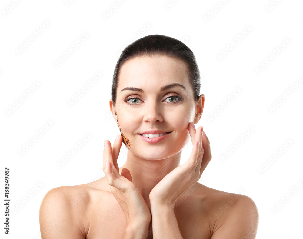 Beautiful young woman applying scrub on face, closeup