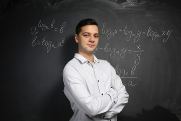 Canvas Print - Handsome young teacher standing near blackboard