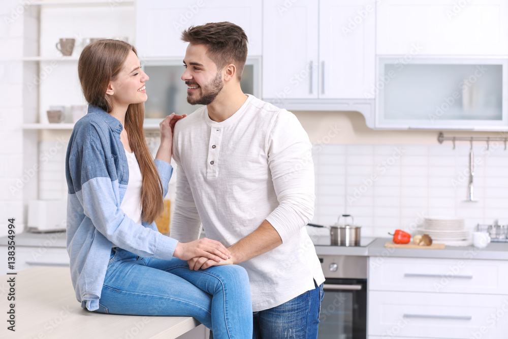 Cute young couple in kitchen at home