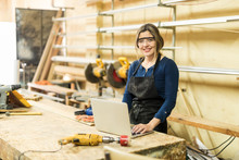 Woman Working In A Woodshop With Laptop