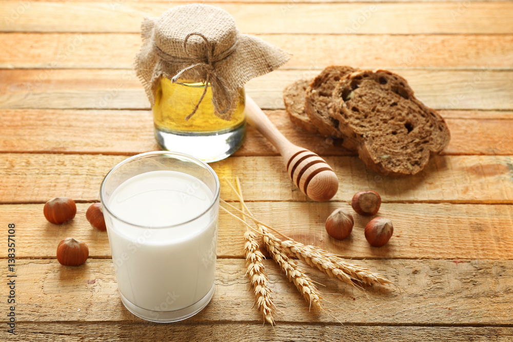 Composition with milk, honey and bread on wooden background