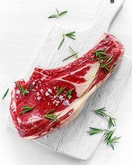 Wall Mural - Fresh Raw Beef bone rib roughly choppid on white board with herbs