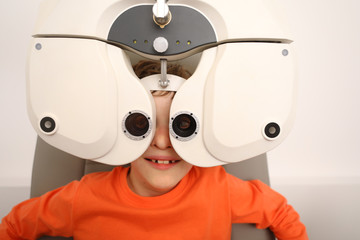 Wall Mural - eye examination, Optometrist in exam room with young boy 
