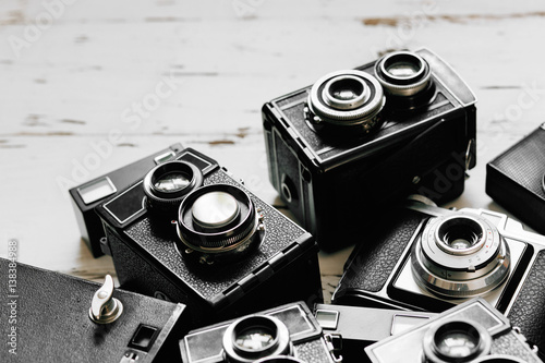Stampa su Tela old vintage retro photo cameras on white wooden background
