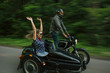 © Garrett Cornelison - Blurred motion image of couple riding motorbike with sidecare