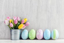 Easter Eggs And A Spring Bouquet Of Tulips On A Wooden Table.
