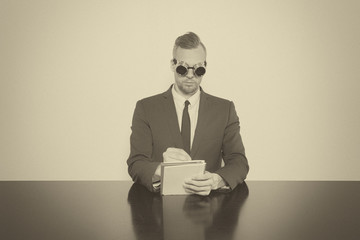 Wall Mural - Businessman sitting at office desk with notepad