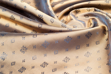 Fabric silk texture color Sandy Brown. With woven into the fabric flowers