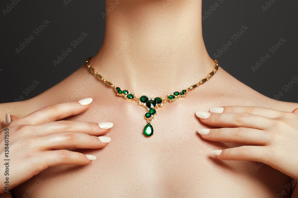 Elegant fashionable woman with jewelry. Beautiful woman with a emerald necklace. Beauty young model with a diamond pendant on a gray background. Jewellery and accessories. - obrazy, fototapety, plakaty 