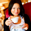 © Raisa Kanareva - young woman sitting in a cafe drinking coffee