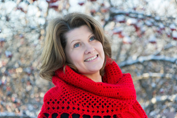 Wall Mural - woman in red shawl in the winter is on background of viburnum