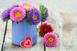 Colorful daisy flowers in blue vase, red heart with  copy space

