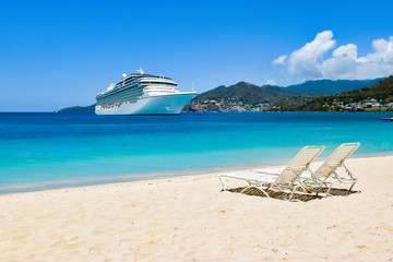 Wall Mural - Cruise ship in Caribbean Sea with beach chairs on white sandy beach.
Summer travel concept.