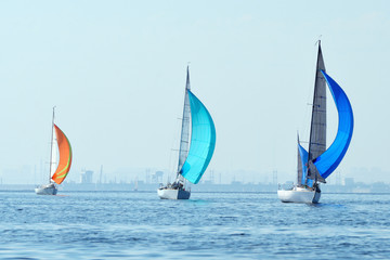 Sailing boats on the river, the reflection on water in the distance shore.