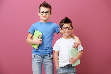 Cute little brothers with books on pink background