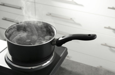 Wall Mural - Metal saucepan on electric stove in kitchen