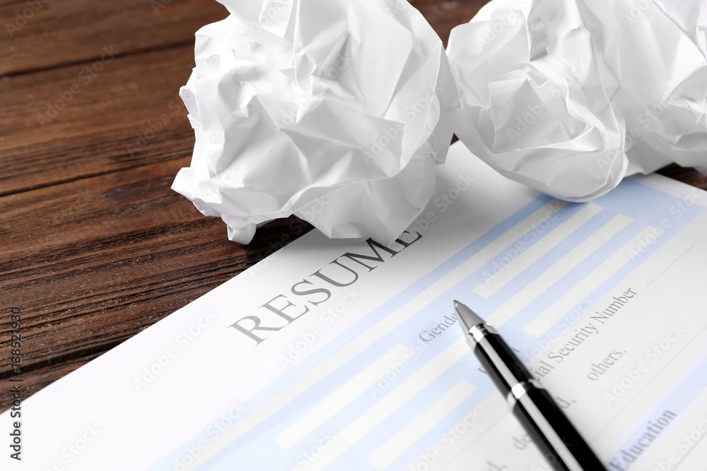 Blank resume form and crumpled paper on wooden table, closeup