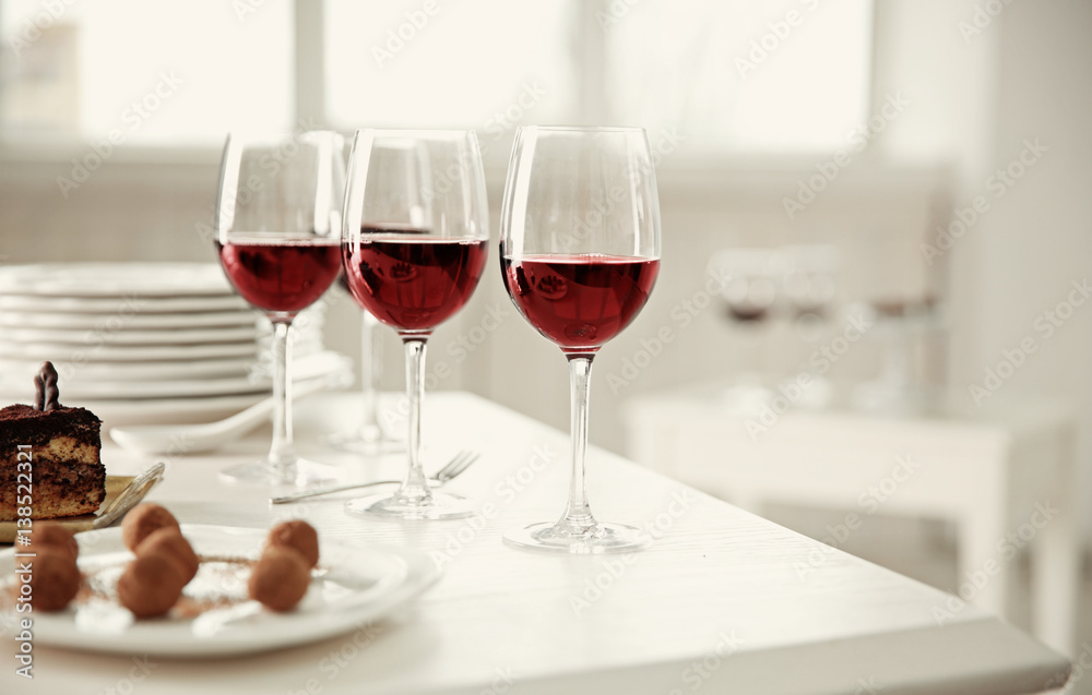 Red wine and delicious chocolate desserts on white table