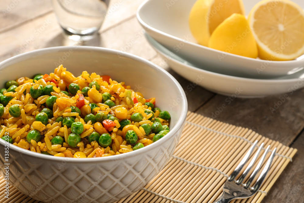 Delicious rice with vegetables in a bowl on table