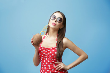 Poster - Young beautiful woman with coconut cocktail on light background