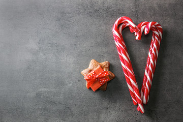 Wall Mural - Sweet candy canes and present box on grey textured background