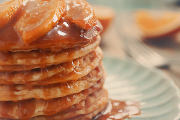 Wall Mural - Delicious pancakes with orange slices and syrup, closeup