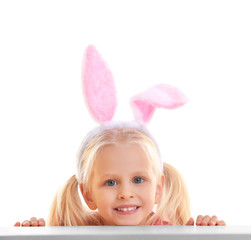 Wall Mural - Cute little girl with bunny ears and basket full of Easter eggs on white background