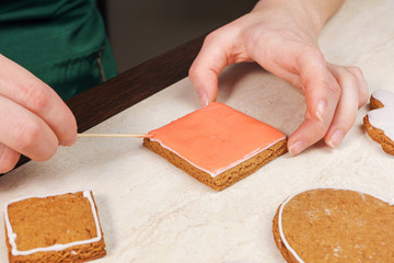 Coating gingerbread shaped as a square with red glaze