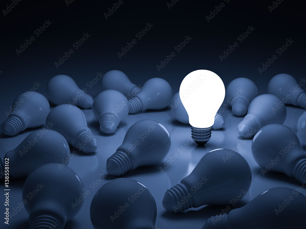 One glowing light bulb standing out from the unlit incandescent bulbs ...