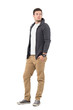 © sharplaninac - Side view of handsome man in gray unzipped sweater with hands in pockets looking back over shoulder. Full body length isolated over white background.
