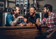 © Fxquadro - Stylish three men drinking craft beer in the microbrewery.