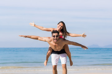 Wall Mural - couple on beach summer vacation, young people happy smiling, man carry woman sea ocean holiday trave