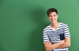Happy teenage boy in casual clothes on color background