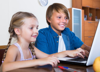 Wall Mural - Children playing online on laptop.