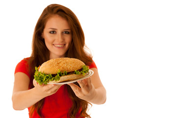 Wall Mural - Unhealthy meal - happy young woman eats hamburger isolated over white