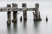 End Of An Old Broken Pier, Closeup Of Posts Standing In Calm Tranquil Water