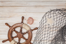 Rudder Of Sailing Ship, Fishing Net With Sea Shells On Wooden Background